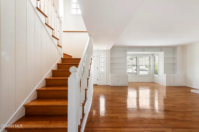 a view of entryway and hall with wooden floor