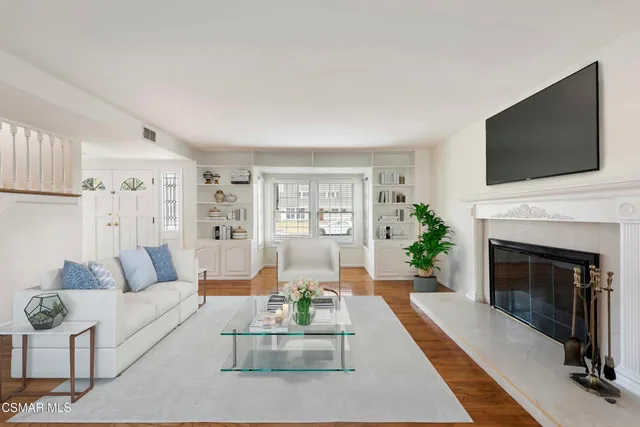 a living room with furniture a flat screen tv and a fireplace