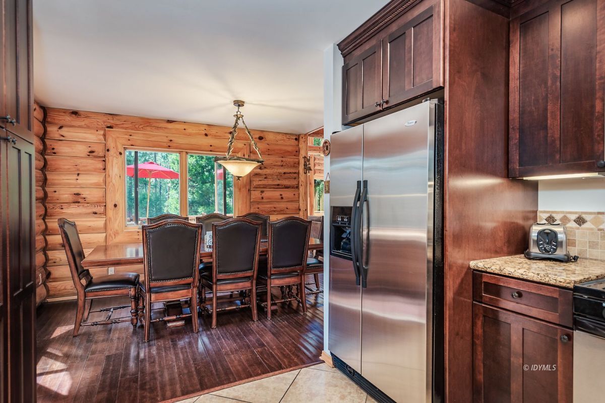 25117 Fern Valley Road Idyllwild, CA 92549 - Photo 28 of 67 a kitchen with stainless steel appliances granite countertop a dining table chairs refrigerator and sink