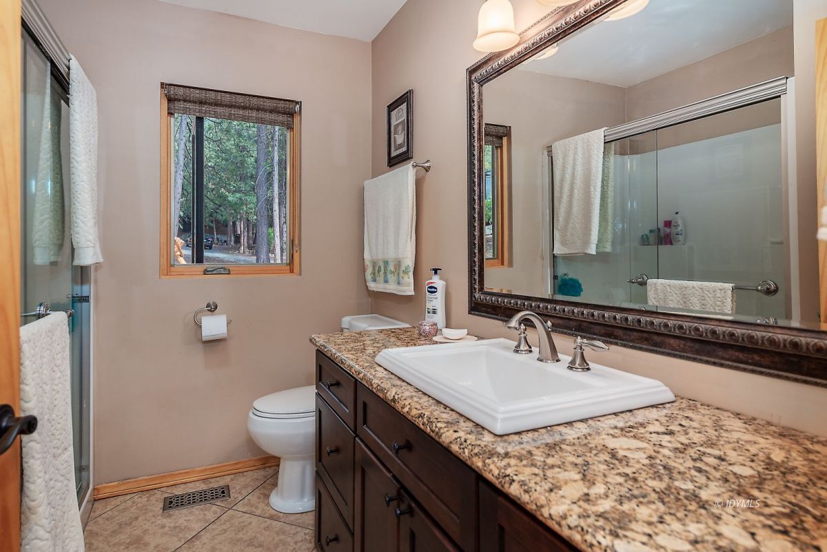 25117 Fern Valley Road Idyllwild, CA 92549 - Photo 31 of 67 a bathroom with a granite countertop sink and a mirror