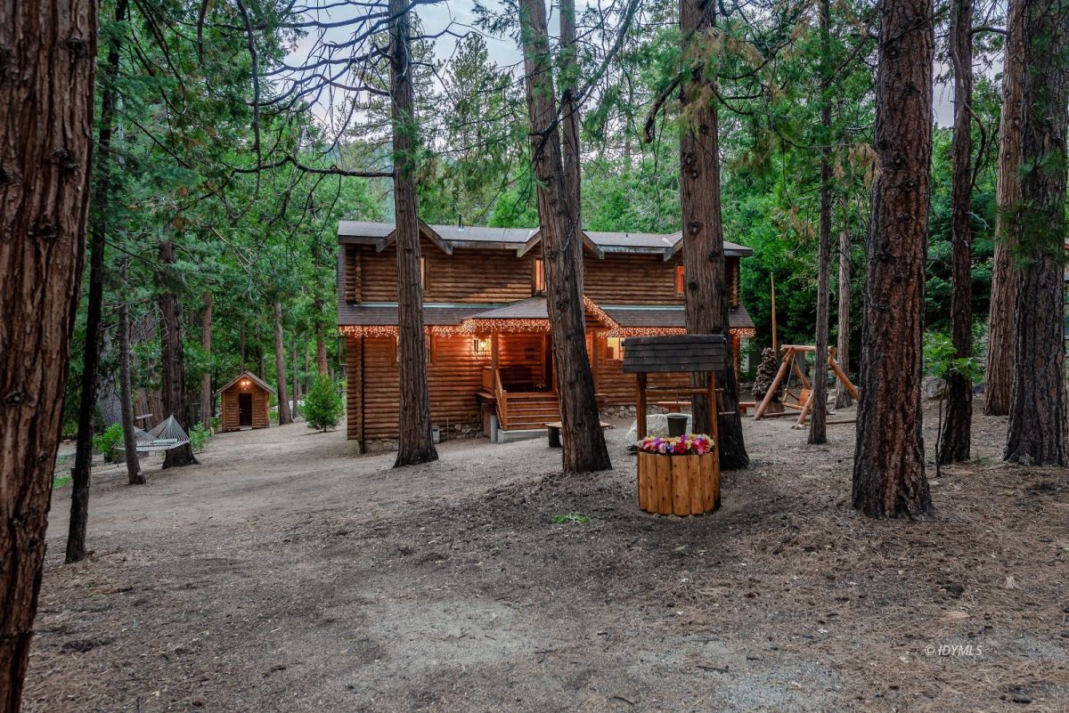 25117 Fern Valley Road Idyllwild, CA 92549 - Photo 61 of 67 a view of a patio with table and chairs potted plants and large tree