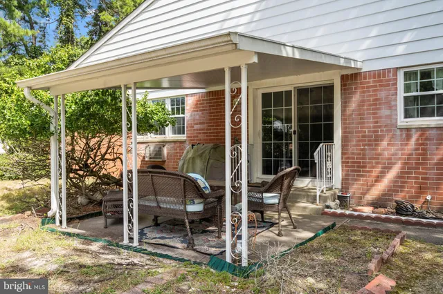 a patio with table and chairs and potted plants
