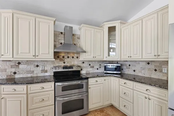 a kitchen with kitchen island granite countertop white cabinets and refrigerator