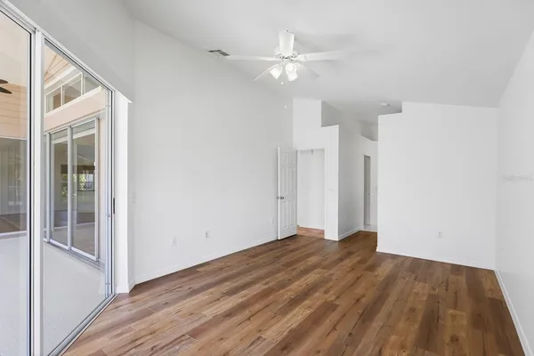 a view of an empty room with wooden floor