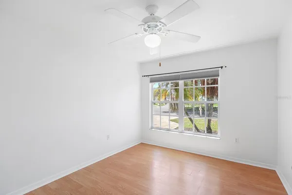 an empty room with a window and wooden floor