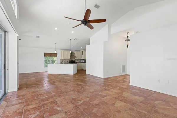 a kitchen with kitchen island granite countertop a sink a refrigerator and cabinets