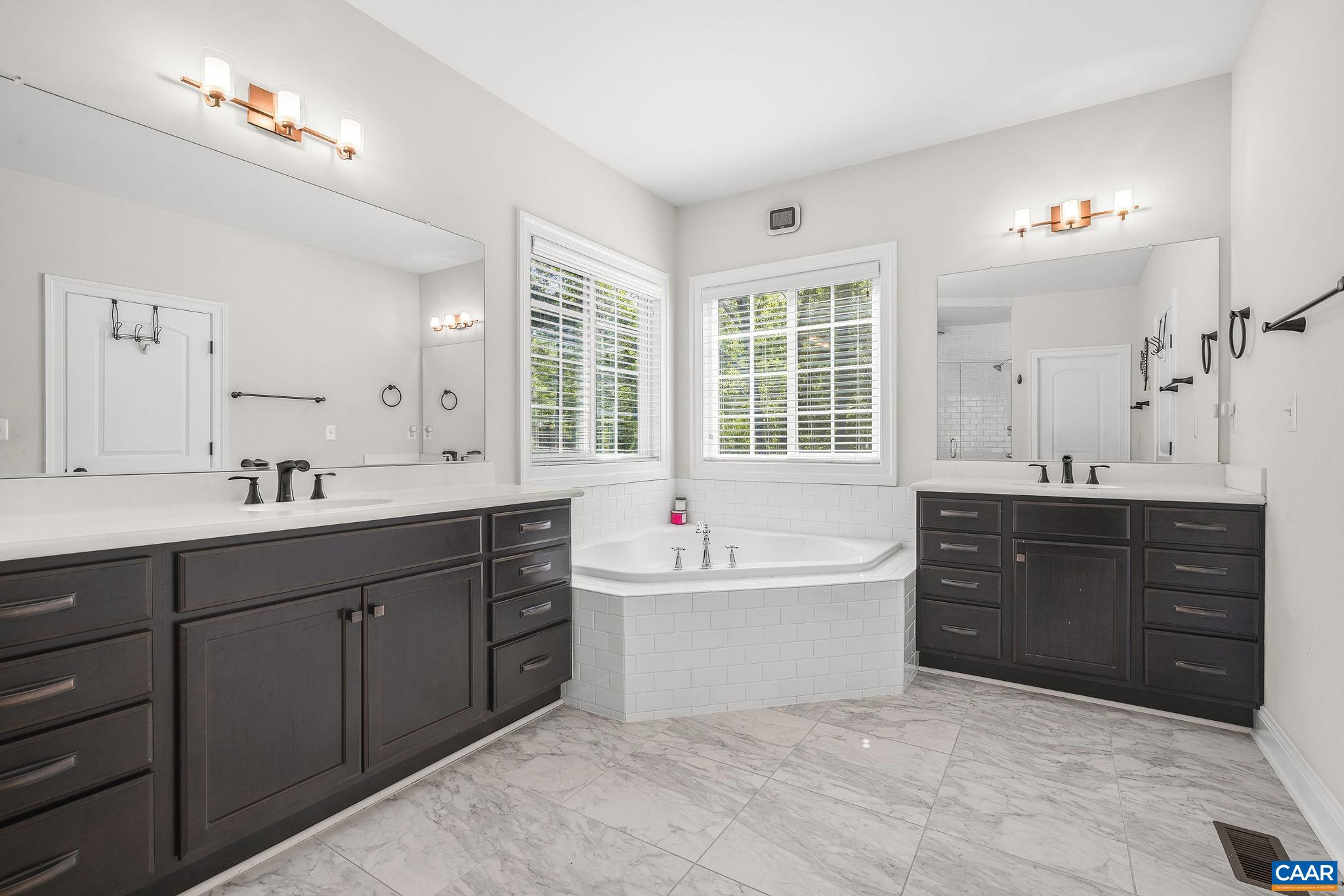 1630 Victor Place Charlottesville, VA 22903 - Photo 38 of 73 a bathroom with a tub sink double vanity and a mirror