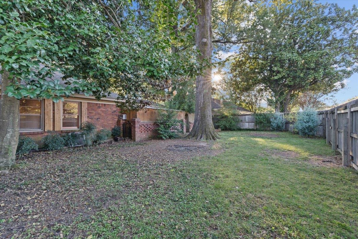 1495 Whitewater Road Memphis, TN 38117 - Photo 26 of 27 a view of a backyard with large trees and wooden fence