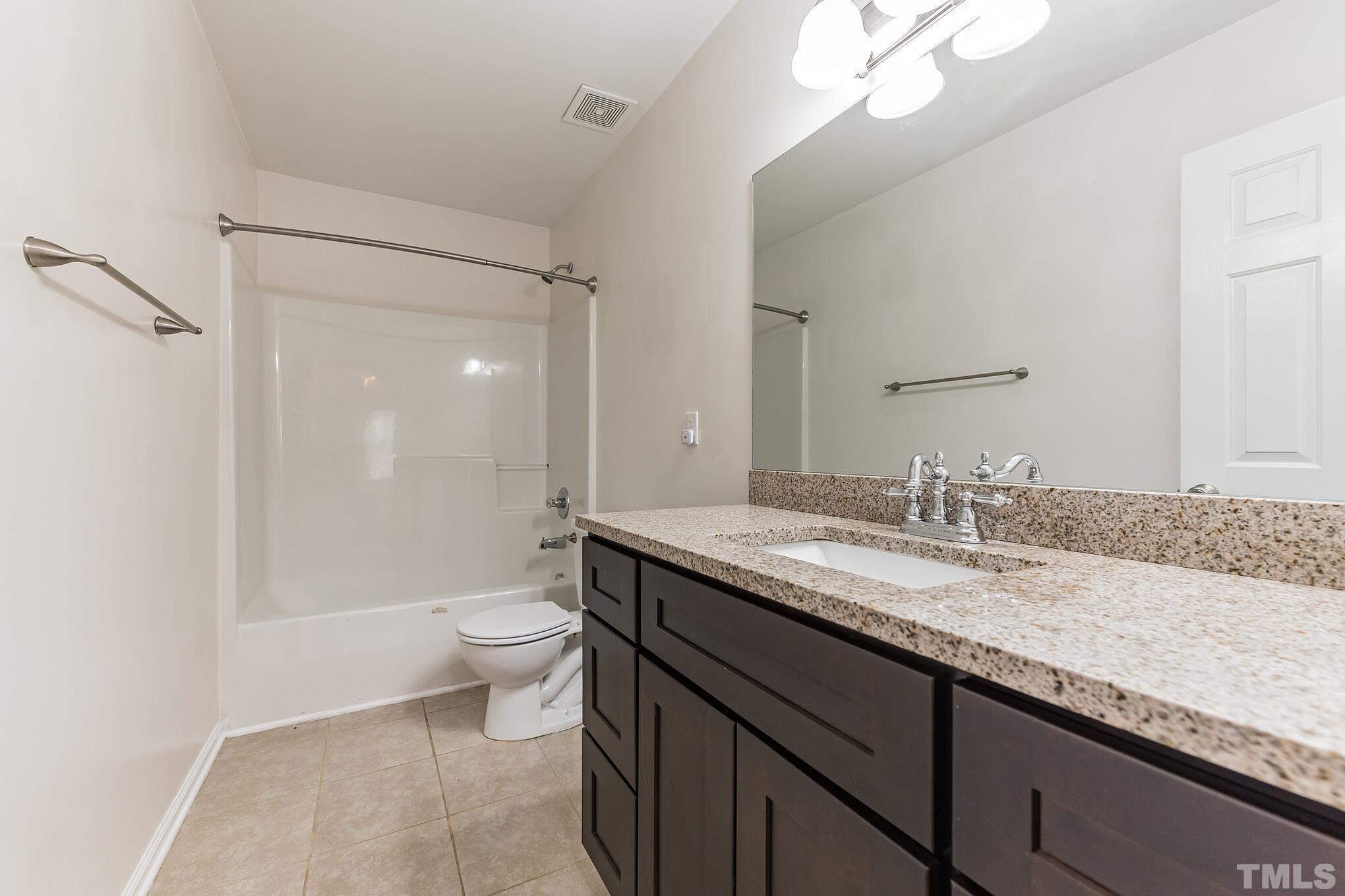 2824 Roundleaf Court Raleigh, NC 27604 - Photo 26 of 35 a bathroom with a granite countertop sink a toilet a mirror and shower