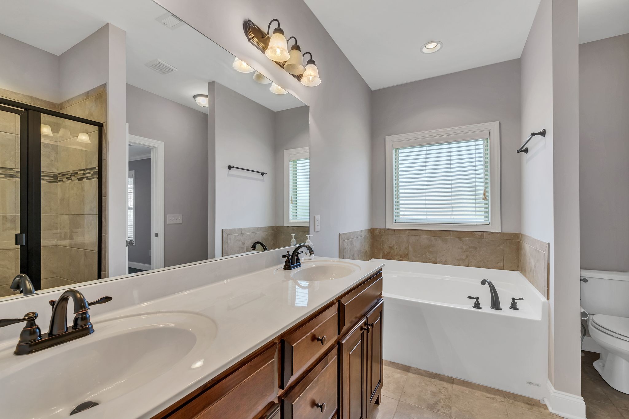 5502 Reflection Road Smyrna, TN 37167 - Photo 13 of 36 a bathroom with a tub a double vanity sink and mirror