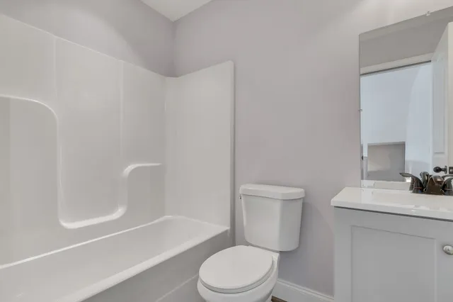 a white toilet sitting next to a bath tub