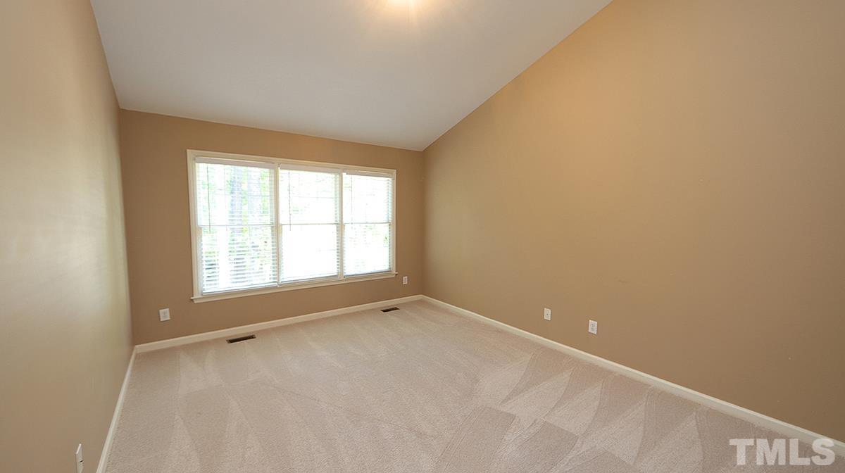 1203 Patterson Grove Road Apex, NC 27502 - Photo 7 of 11 The primary bedroom on the first floor has vaulted ceiling.
