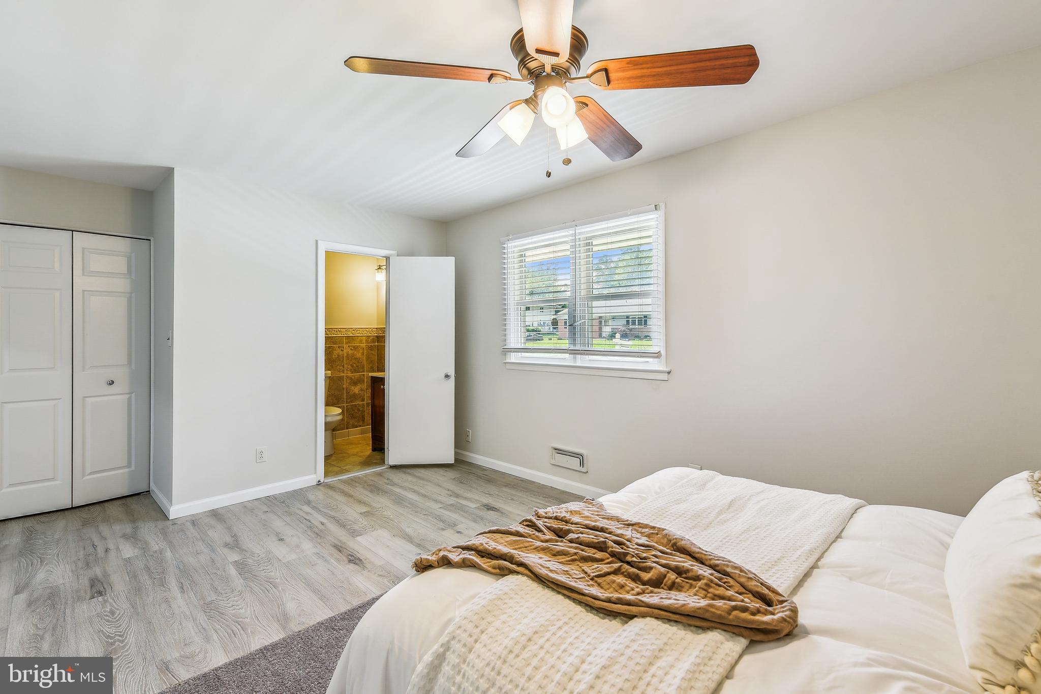 8148 Scotts Level Road Pikesville, MD 21208 - Photo 17 of 36 a bedroom with a bed and a chandelier