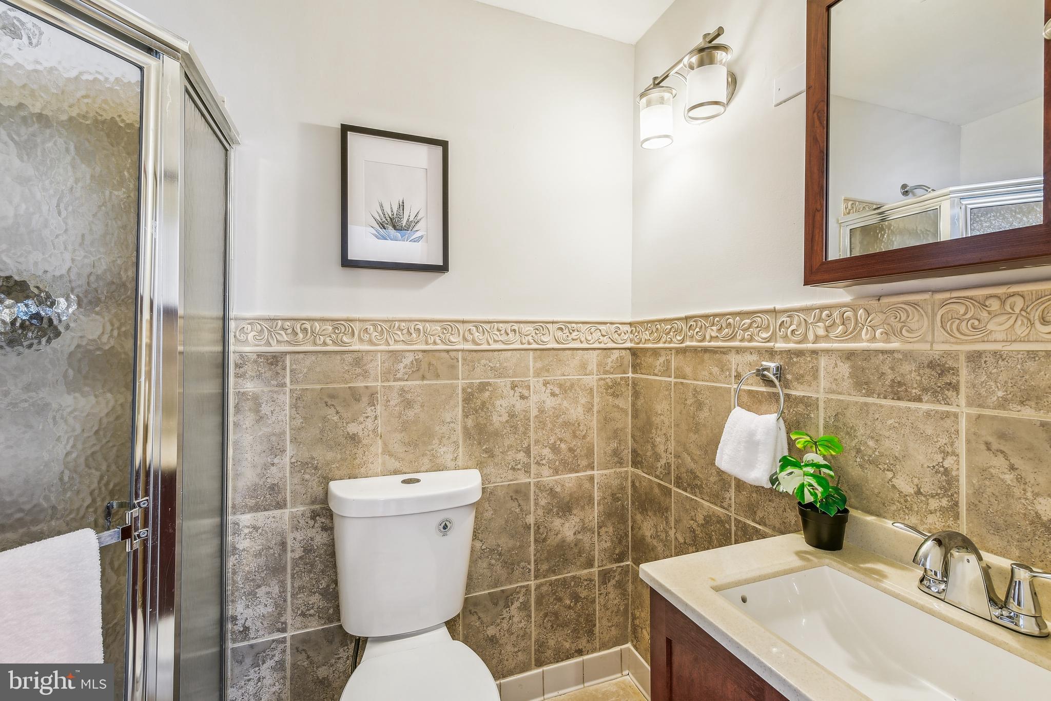 8148 Scotts Level Road Pikesville, MD 21208 - Photo 19 of 36 a bathroom with a sink a toilet and a mirror