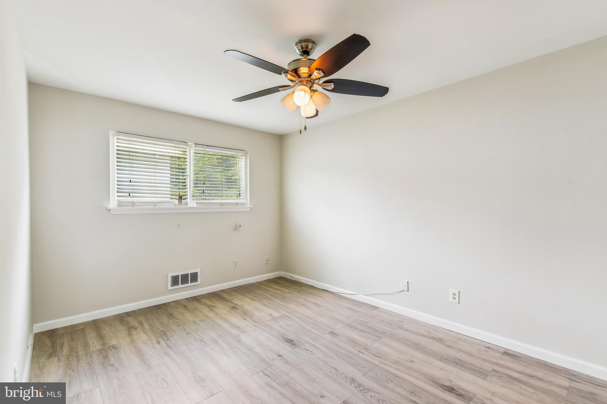 8148 Scotts Level Road Pikesville, MD 21208 - Photo 22 of 36 a view of wooden floor and a chandelier fan in a room