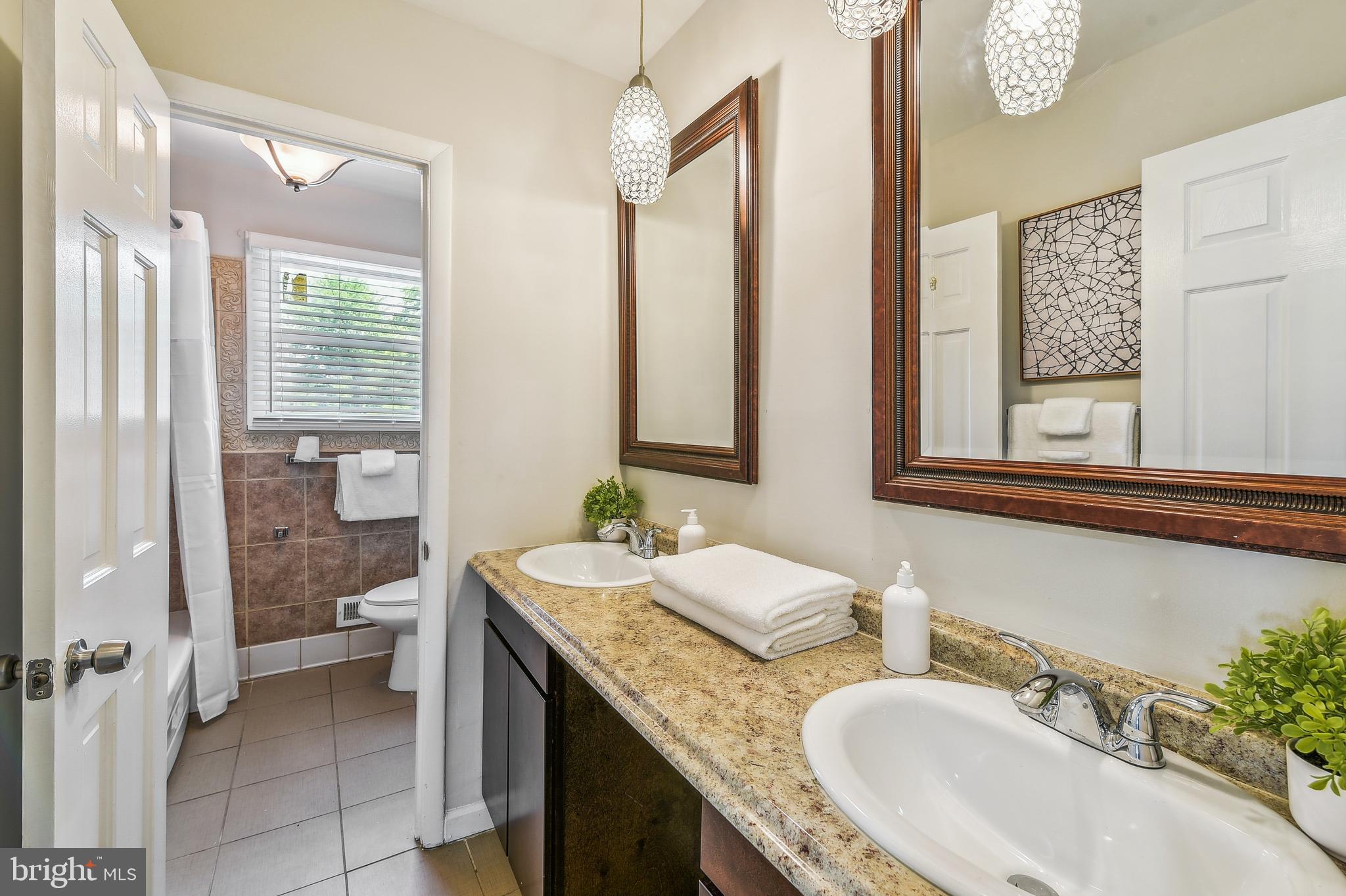 8148 Scotts Level Road Pikesville, MD 21208 - Photo 24 of 36 a bathroom with a granite countertop sink and a mirror