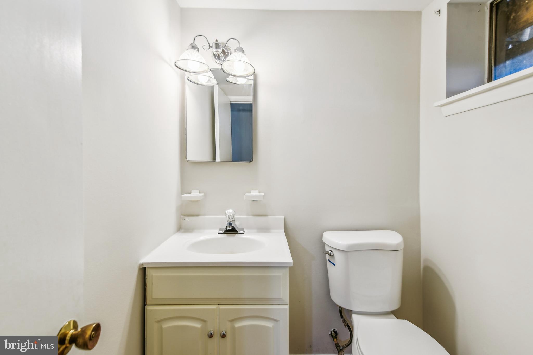 8148 Scotts Level Road Pikesville, MD 21208 - Photo 26 of 36 a bathroom with a toilet sink and mirror