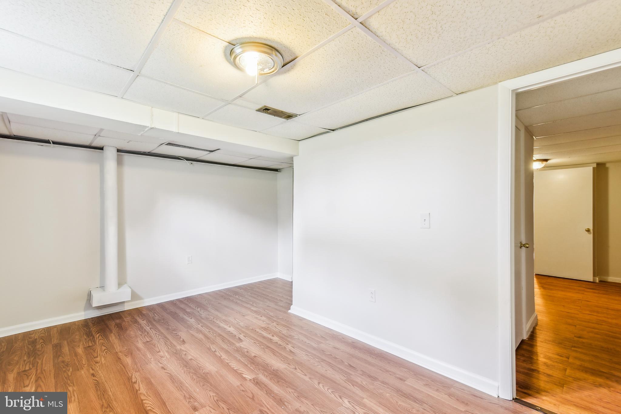 8148 Scotts Level Road Pikesville, MD 21208 - Photo 31 of 36 a view of empty room with wooden floor