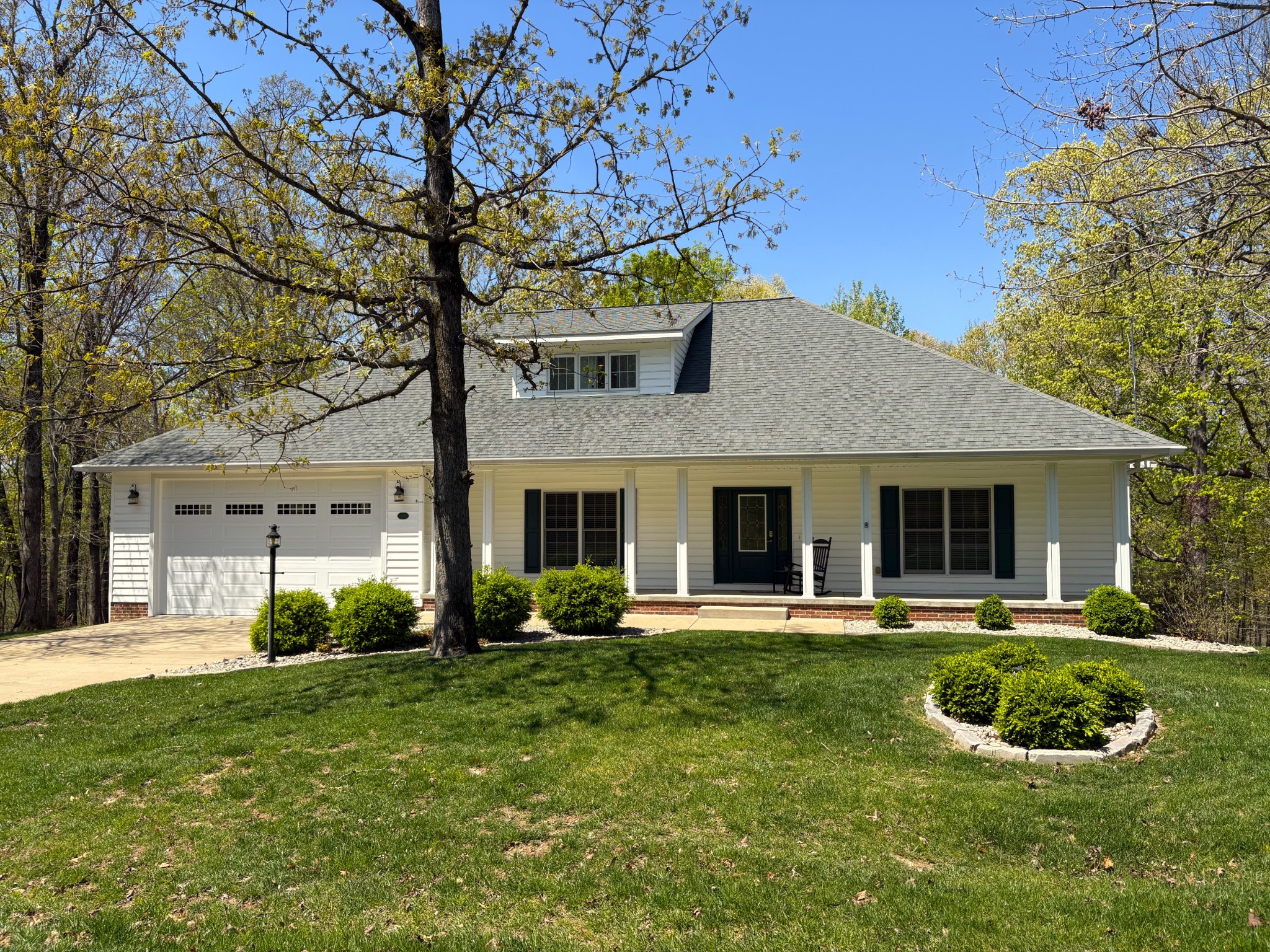 a front view of a house with a yard and potted plants