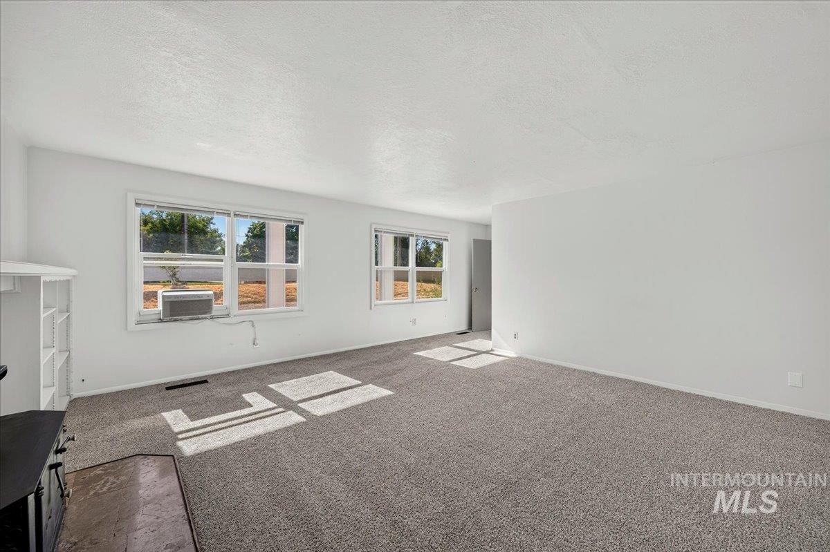 2160 South Five Mile Road Boise, ID 83709 - Photo 20 of 41 Spacious living area featuring light gray carpeting, crisp white walls, and multiple windows allowing natural illumination