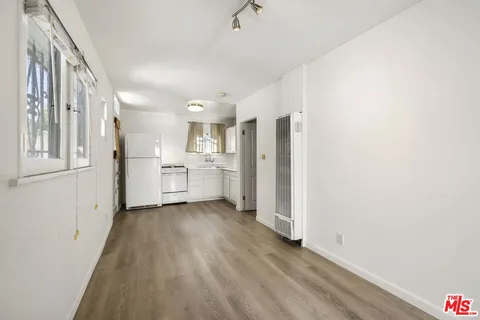 a view of a kitchen with a refrigerator a sink and dishwasher a refrigerator with wooden floor