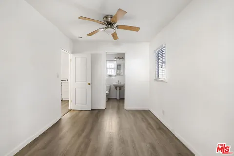 a view of a livingroom with wooden floor and a ceiling fan