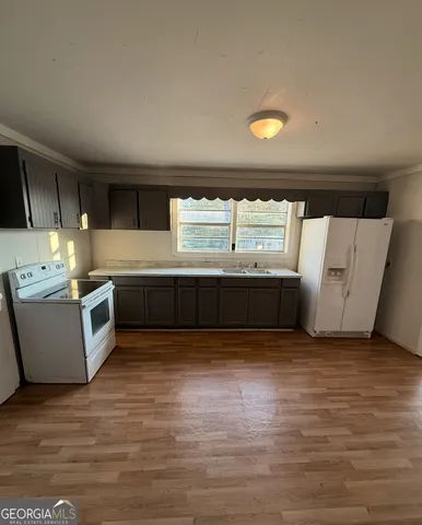 a view of kitchen with granite countertop a sink and a stove