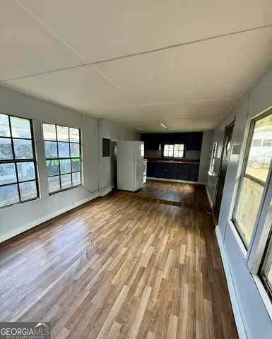 a view of empty room with windows and wooden floor