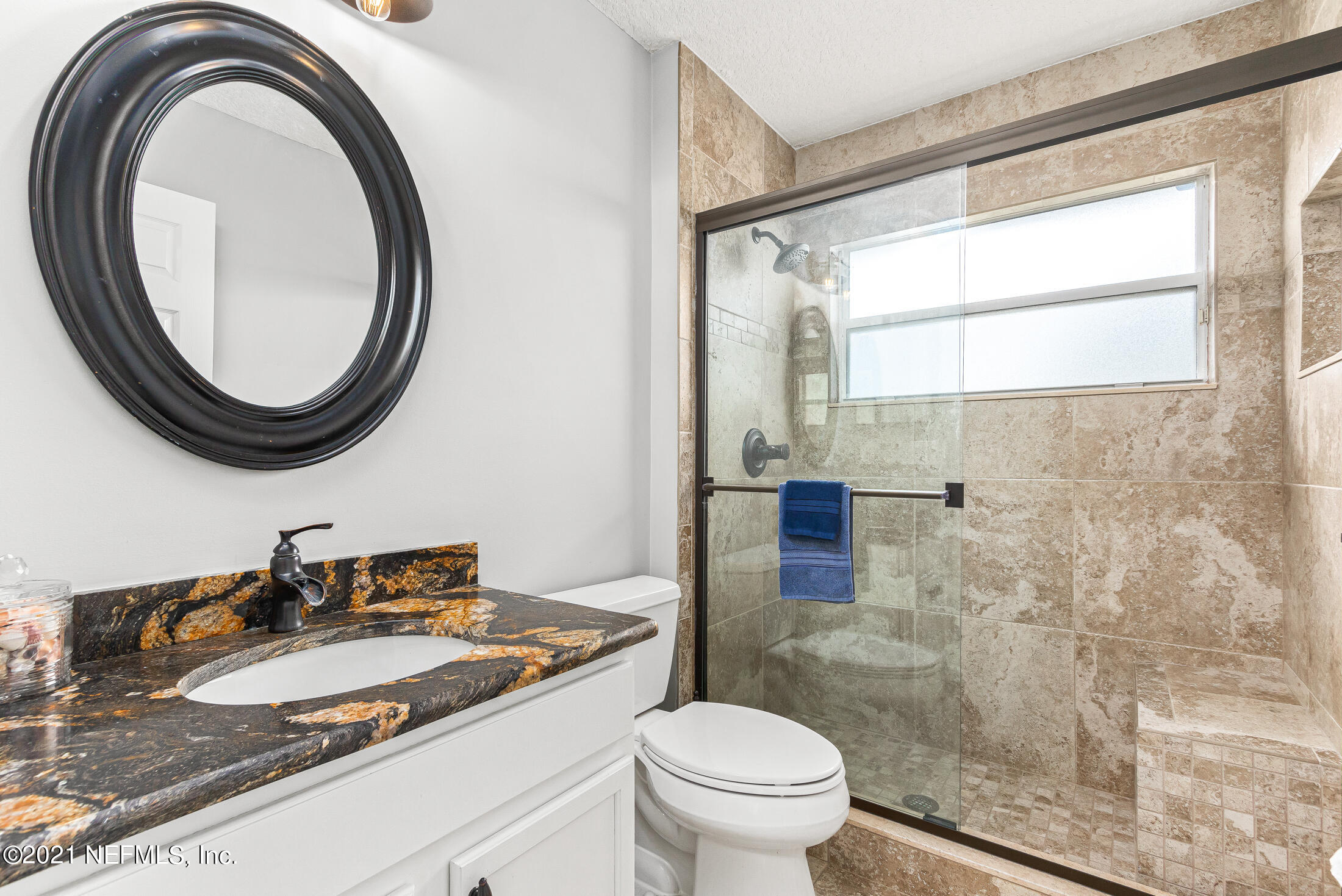 856 Crystal Spring Way St. Augustine, FL 32092 - Photo 24 of 54 a bathroom with a granite countertop toilet a sink and a mirror