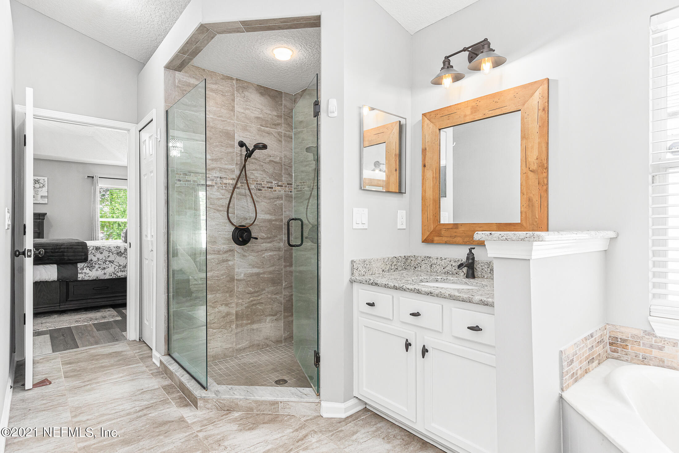 856 Crystal Spring Way St. Augustine, FL 32092 - Photo 29 of 54 a bathroom with a granite countertop sink mirror and shower
