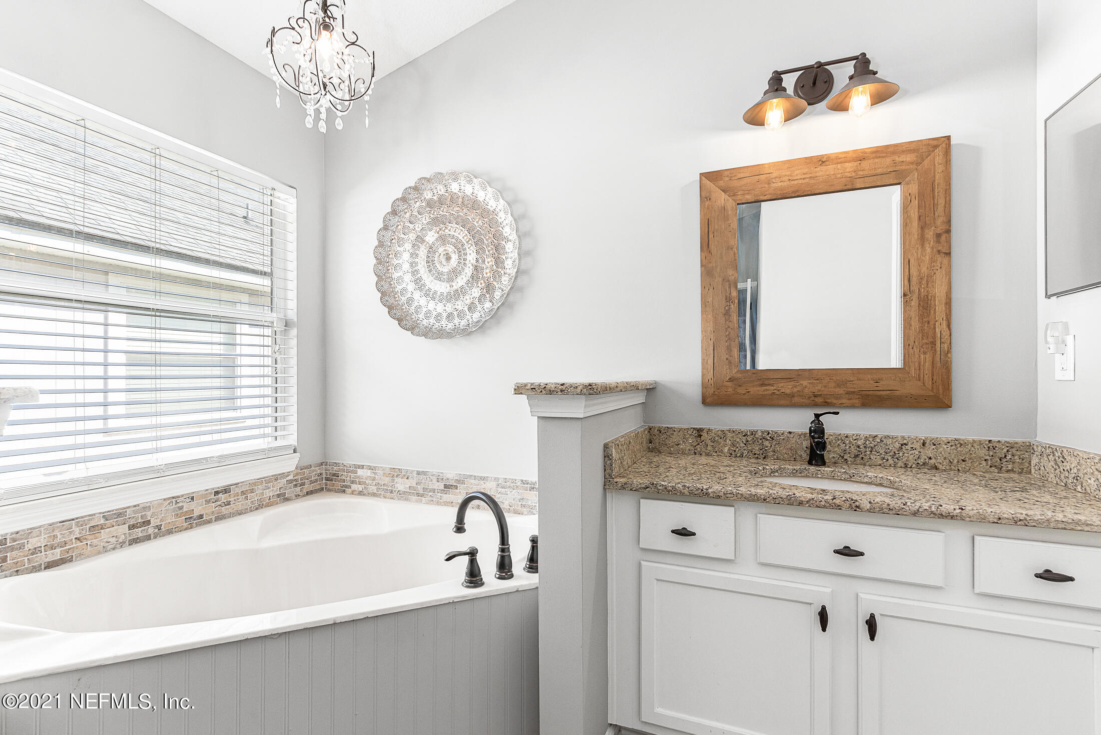 856 Crystal Spring Way St. Augustine, FL 32092 - Photo 32 of 54 a bathroom with a granite countertop bathtub a sink and mirror