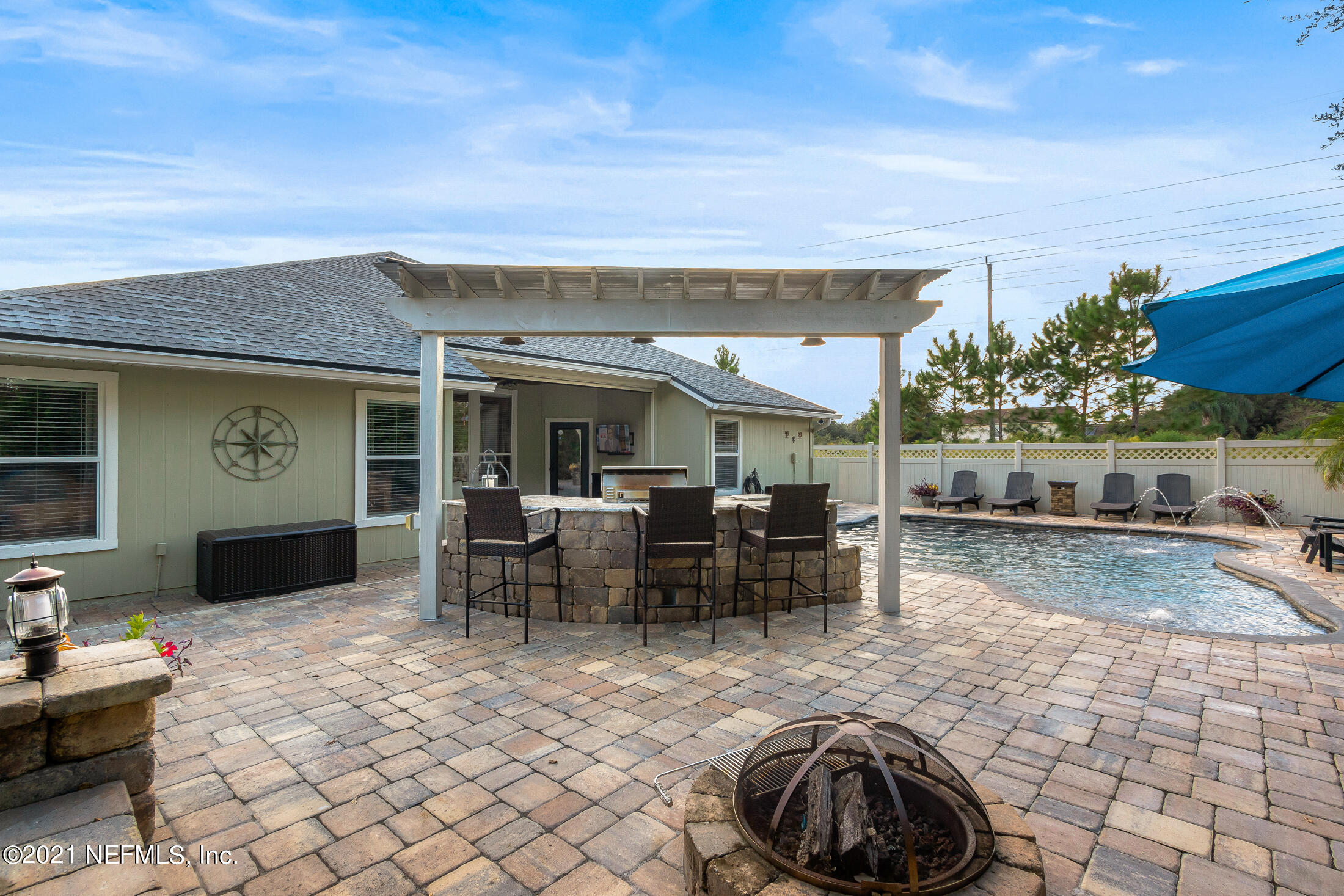 856 Crystal Spring Way St. Augustine, FL 32092 - Photo 42 of 54 a view of a patio with dining table and chairs with wooden fence