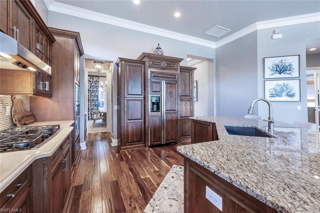 3086 Aviamar Circle Naples, FL 34114 - Photo 13 of 50 a kitchen with granite countertop a sink stove and refrigerator