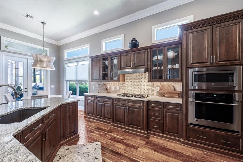 3086 Aviamar Circle Naples, FL 34114 - Photo 14 of 50 a large kitchen with stainless steel appliances granite countertop a stove and a sink