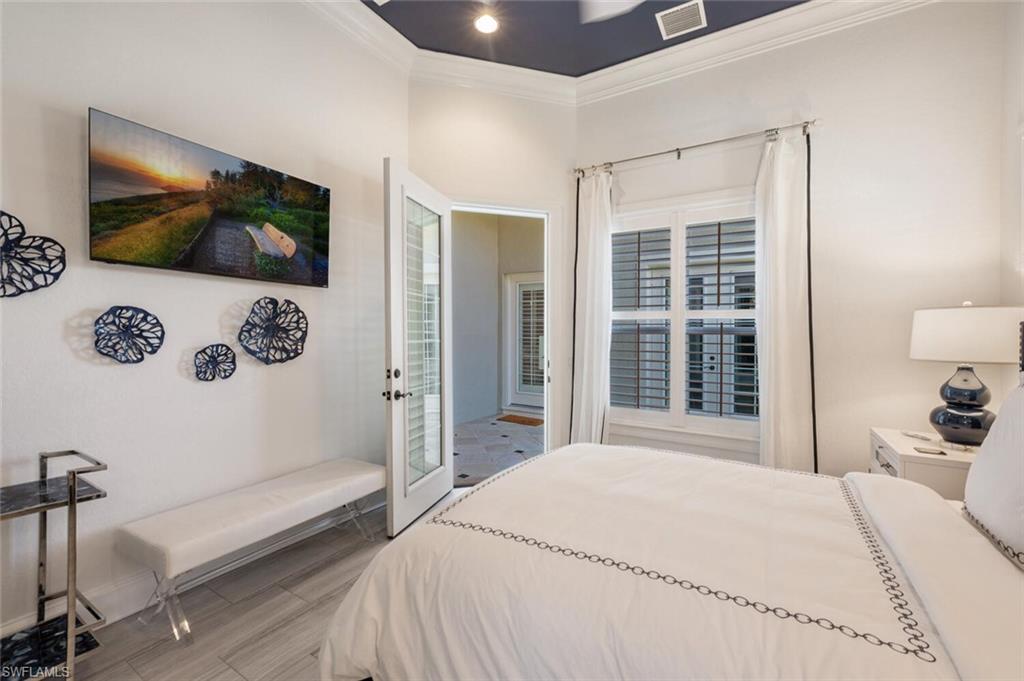 3086 Aviamar Circle Naples, FL 34114 - Photo 34 of 50 a bedroom with a bed a flat screen tv and balcony