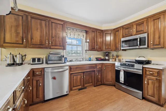 a kitchen with stainless steel appliances granite countertop a sink a stove top oven a counter space and cabinets