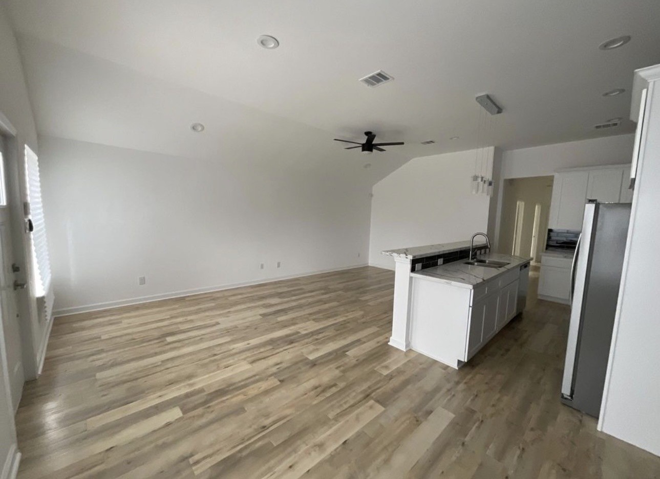 5202 Northridge Drive, Unit B Houston, TX 77033 - Photo 4 of 12 a kitchen with a refrigerator and white cabinets