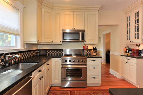 17 Garth Road Boston, MA 02132 - Photo 8 of 25 a kitchen with granite countertop a stove a sink and a microwave