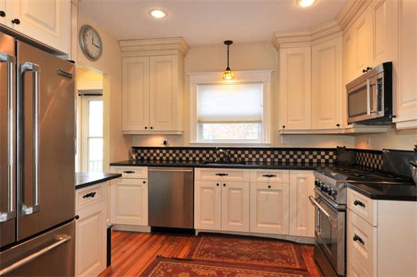17 Garth Road Boston, MA 02132 - Photo 9 of 25 a kitchen with stainless steel appliances granite countertop a stove a sink and a refrigerator