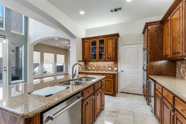a kitchen with granite countertop stainless steel appliances a sink stove and cabinets