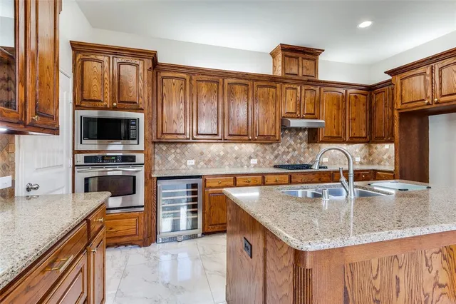 a kitchen with granite countertop a stove a sink and a microwave