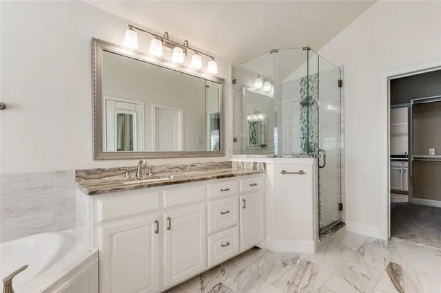a bathroom with a granite countertop sink mirror and a shower