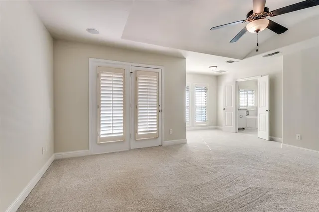 a view of empty room with windows and ceiling fan