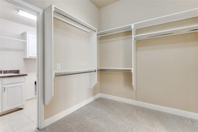 a view of an empty walk in closet and a window