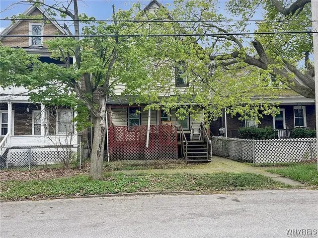 a front view of a house with a garden