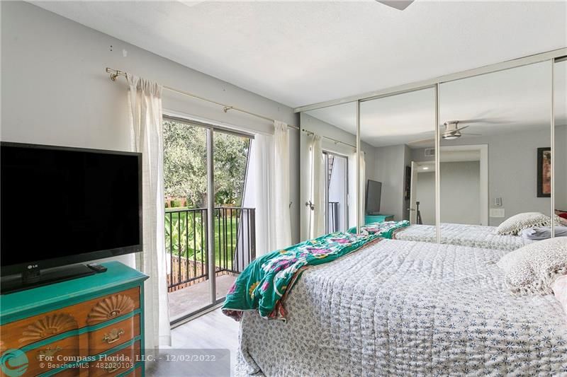 2929 Southwest 22nd Circle, Unit 32B Delray Beach, FL 33445 - Photo 18 of 22 a bedroom with a bed and a flat tv screen on dresser