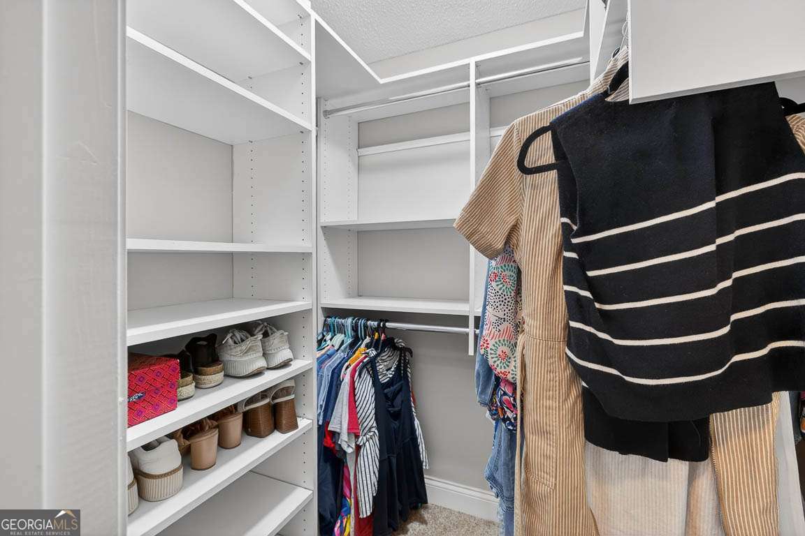 2514 Demere Road, Unit 7 St. Simons, GA 31522 - Photo 20 of 22 a view of walk in closet with clothes and shoes