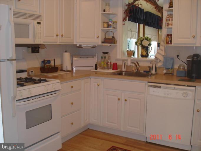 3317 Offutt Road Randallstown, MD 21133 - Photo 3 of 13 a kitchen with white cabinets and white appliances