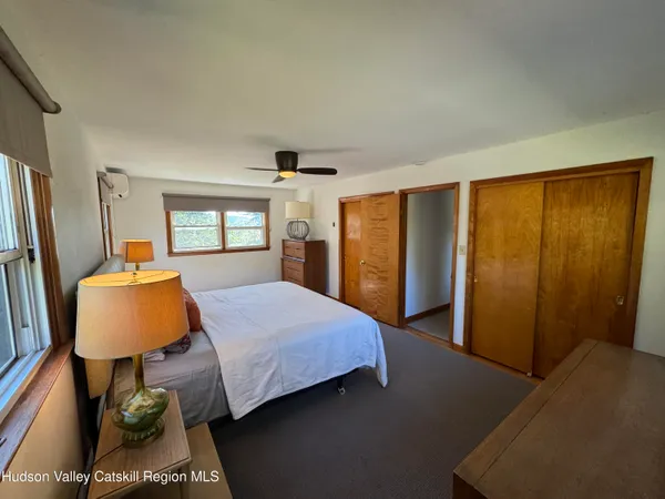 a bedroom with a bed flat screen tv and window