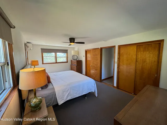 a bedroom with a bed flat screen tv and window